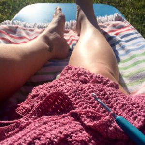 Crocheting on the sun lounge.